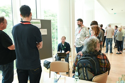 People standing and sitting in front of a pinboard talking