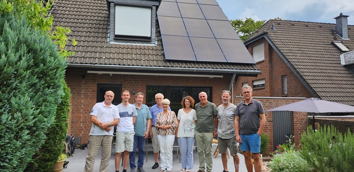 People standing in front of house with solar panels