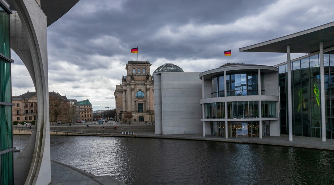 Ein Gebäude neben einem Gewässer unter einem bewölkten Himmel